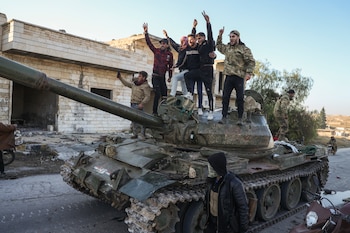 Partidarios de la oposición siria celebran arriba de un tanque de guerra del ejército sirio en el poblado de Maarat al-Numan, al suroeste de Alepo, Siria, el sábado 30 de noviembre de 2024 (AP Foto/Omar Albam)