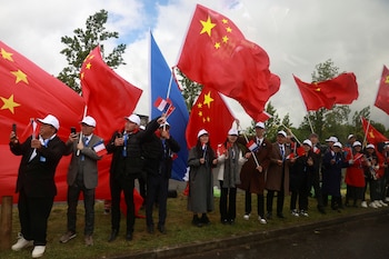 Varias personas ondean banderas chinas
