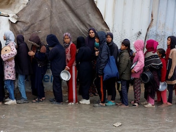 Palestinos hacen cola para recibir