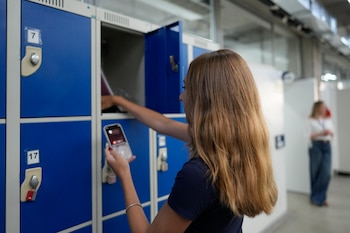 Una alumna guarda su teléfono