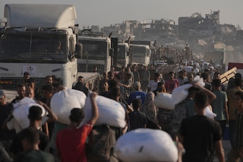 Palestinos cargan sacos de harina