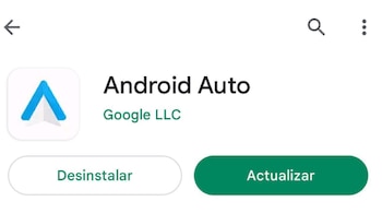 Vista interior de un automóvil: la mano de un conductor toca una pantalla táctil con navegación y logos de Android Auto y Apple CarPlay. El volante está a la izquierda.
