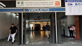 Entrada a la estación Viaducto del Metro de la Ciudad de México con personas caminando, un letrero azul de "VIADUCTO" y señalización de "SERVICIO DE APOYO RTP"