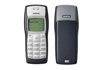 Dos vistas de un Nokia 1100 sobre fondo blanco: la frontal con pantalla verde mostrando 'Insert SIM' y teclado, y la trasera con su diseño clásico.