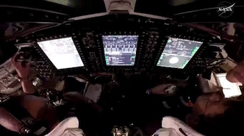 Vista desde arriba de los astronautas de la NASA Victor Glover (izquierda) y Reid Wiseman (derecha), piloto y comandante, respectivamente, dentro de la nave espacial Orion mientras participan en una demostración de operaciones de proximidad.