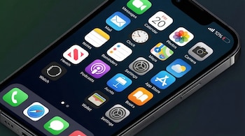 Primer plano de la pantalla de un iPhone mostrando su menú principal con varias aplicaciones y el icono de batería indicando un 10% de carga.